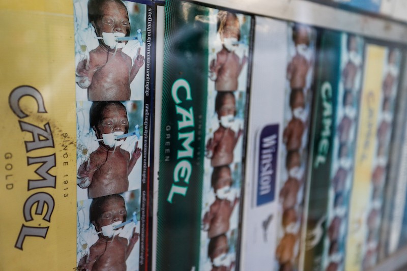 The image of an infant breathing through a respirator due to second-hand smoke is seen on cartons of cigarettes at a store in Phnom Penh on Monday. (Siv Channa/The Cambodia Daily)