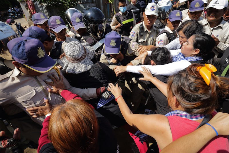 Activists and government security guards clash in Phnom Penh’s Boeng Kak neighborhood yesterday during a protest to mark the ninth ‘Black Monday.’ (Satoshi Takahashi)