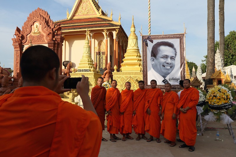 Monks pose for a photograph below a portrait of slain political analyst Kem Ley at Wat Chas pagoda in Phnom Penh on Saturday. (Satoshi Takahashi)