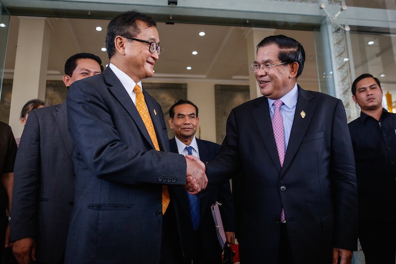 Opposition leader Sam Rainsy, left, shakes hands with Prime Minister Hun Sen after the National Assembly approved the composition of the new National Election Committee in April last year. (Siv Channa/The Cambodia Daily) 