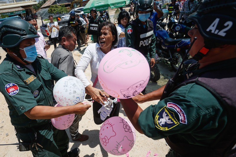 Activist Im Srey Touch tussles with police attempting to confiscate banners and balloons during a protest to mark the ninth ‘Black Monday’ in Phnom Penh yesterday. (Siv Channa/The Cambodia Daily)