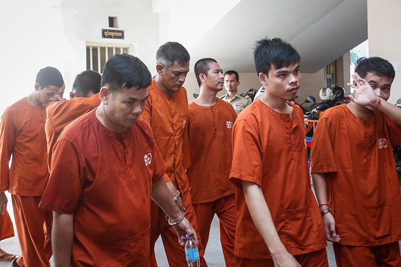 Thong Sarath's bodyguards Chhun Chetra, front left, and Sieng Veasna, to his left, arrive at the Phnom Penh Municipal Court on Friday. (Siv Channa/The Cambodia Daily)