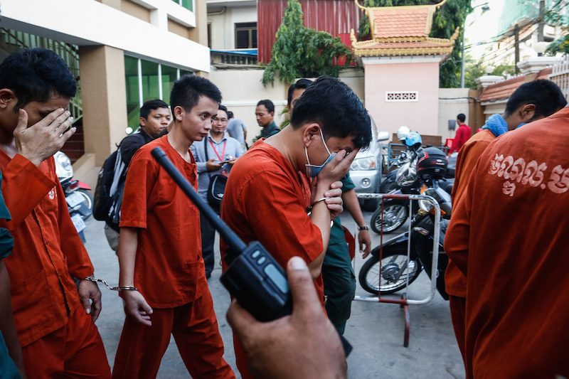 Lay Tharoat, center, an official at the Council for the Development of Cambodia, leaves the Phnom Penh Municipal Court on Monday. (Siv Channa/The Cambodia Daily)