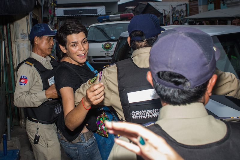 Spanish academic Marga Bujosa Segado is pushed into a police van outside her home in Phnom Penh on Wednesday evening. (Hannah Hawkins/The Cambodia Daily) 