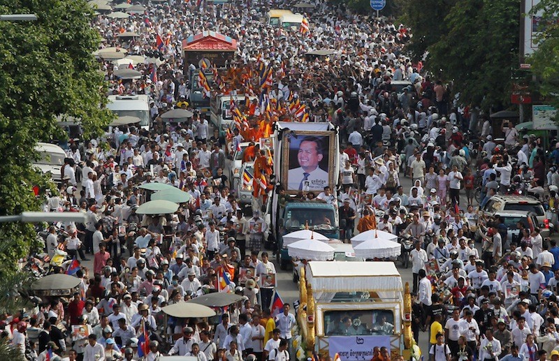Thousands of mourners escort the body of slain political analyst Kem Let through Phnom Penh last month on their way to his hometown in Takeo province. (Pring Samrang/Reuters)