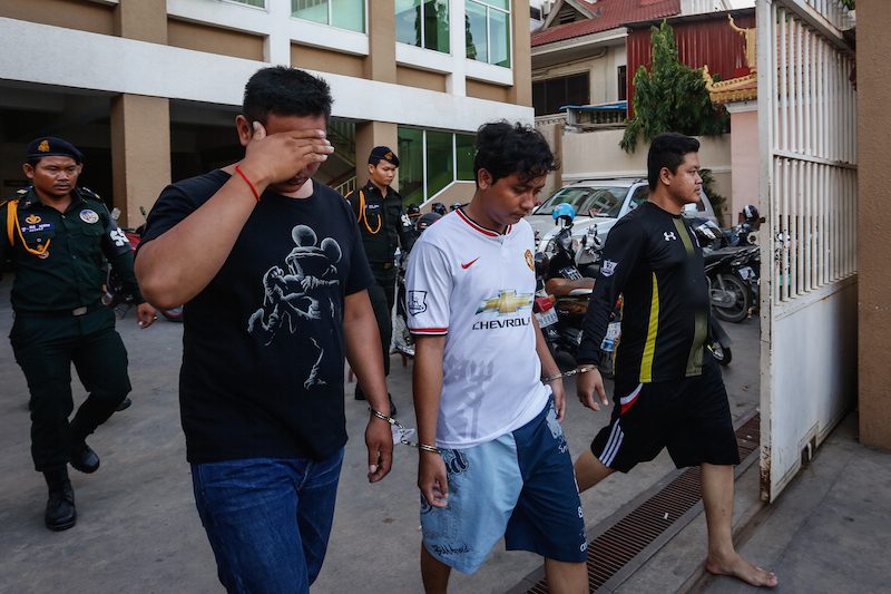Three men suspected in the shooting of a mini-mart employee in Phnom Penh on Saturday leave the municipal court after questioning on Tuesday. (Siv Channa/The Cambodia Daily)