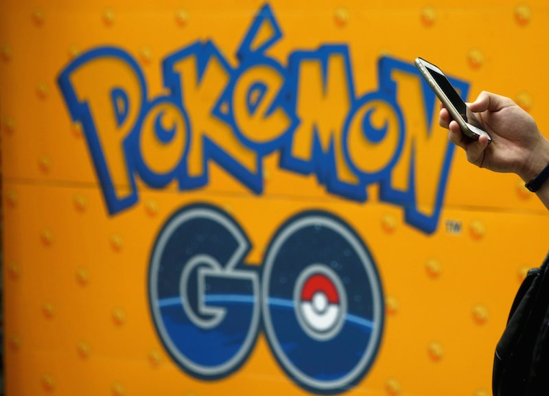 A man uses a mobile phone in front of an advertisement for Pokemon Go at an electronic shop in Tokyo last month. (Reuters)