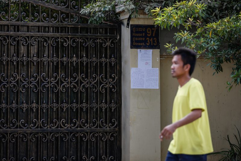 A man walks past the residence of deputy opposition leader Kem Sokha in Phnom Penh, where court documents were posted on Thursday announcing that he had been charged for skipping court. (Siv Channa/The Cambodia Daily)