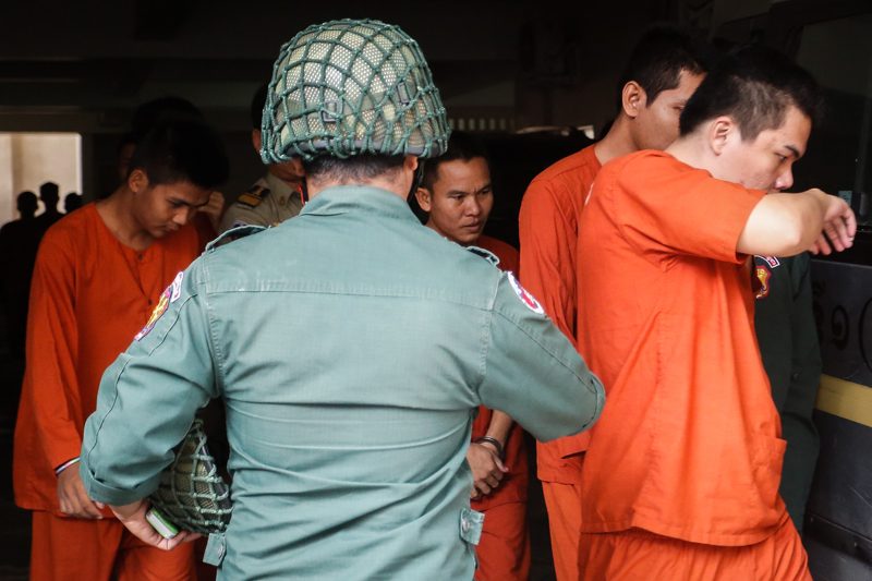 Oeuth Ang, center, leaves the Phnom Penh Municipal Court after being questioned on Friday. (Siv Channa/The Cambodia Daily)