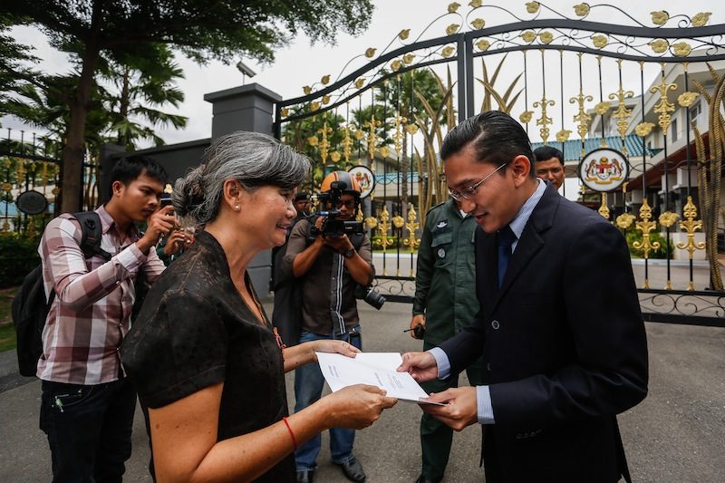 Opposition lawmaker Mu Sochua hands a letter to an official outside the Malaysian Embassy in Phnom Penh on Monday. (Siv Channa/The Cambodia Daily)