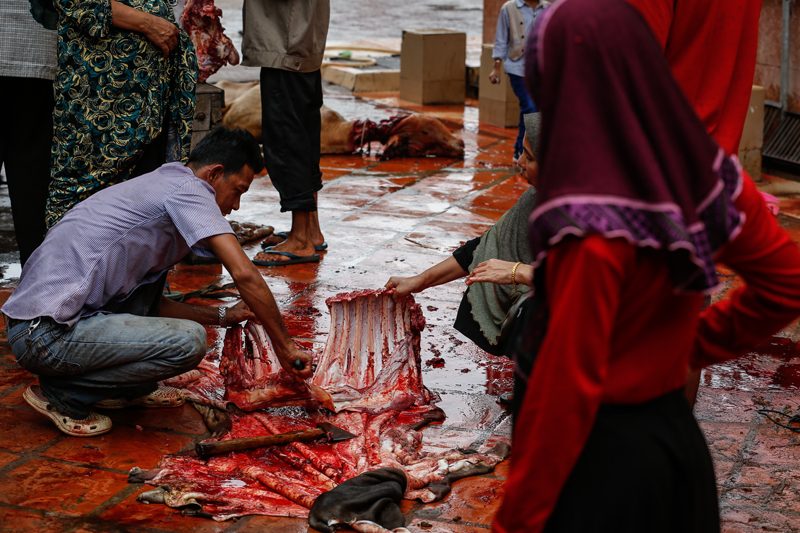 Members of Cambodia’s Muslim community butcher a cow at Phnom Penh’s Nussunain Mosque on Monday during a celebration marking the holiday of Eid al-Adha. (Siv Channa/ The Cambodia Daily)