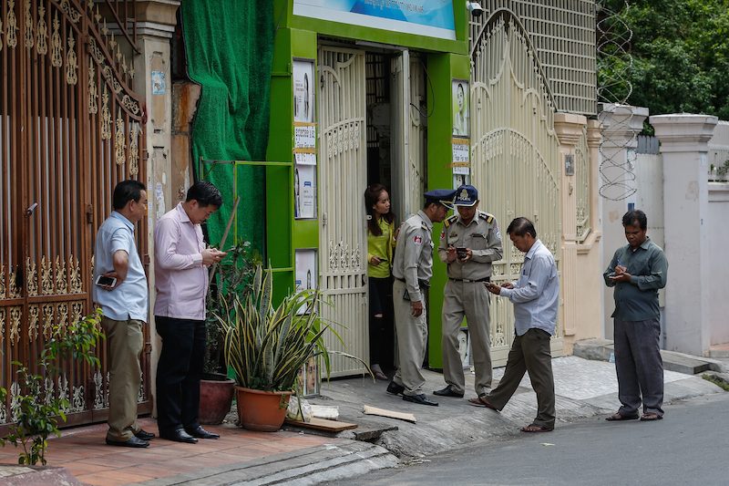 Police interview residents on Wednesday about Tuesday night's grenade blast on Street 163 in Phnom Penh. (Siv Channa/The Cambodia Daily)