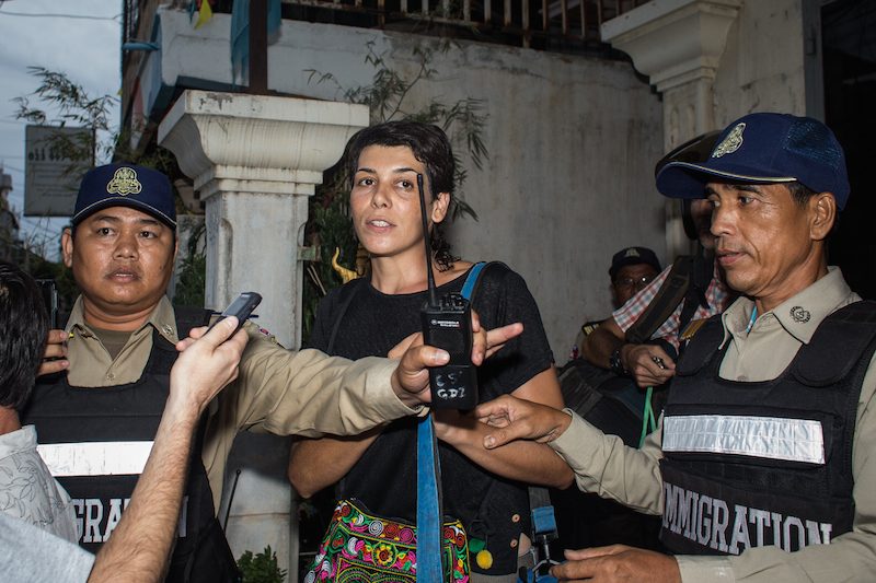 Marga Bujosa Segado is escorted from her apartment in Phnom Penh's Boeng Kak neighborhood before being deported last month. (Hannah Hawkins/The Cambodia Daily)