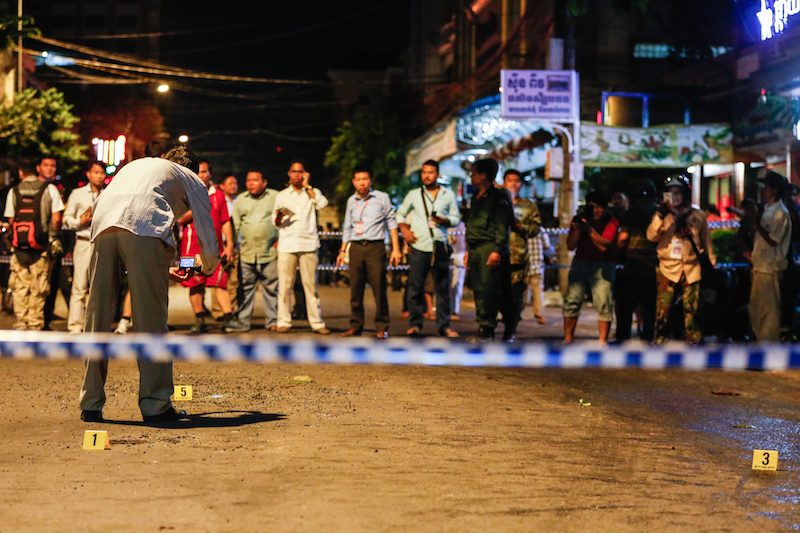 A man takes photographs of the scene of a grenade blast in Phnom Penh earlier this month. (Siv Channa/The Cambodia Daily) 