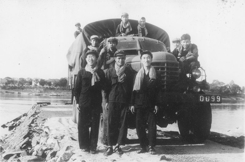 Khmer Rouge cadre and Chinese advisers stand in front of a military truck during Democratic Kampuchea. (The family of Um Sarun/DC-CAM)