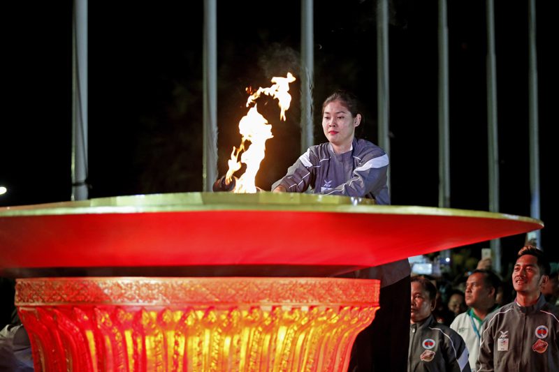 Asian Games gold medalist Sorn Seavmey lights a cauldron during the opening ceremony of the first ­National Games at Phnom Penh's Olympic Stadium on Friday night. (Siv Channa/The Cambodia Daily)