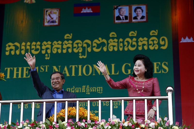 Prime Minister Hun Sen and his wife, Bun Rany, wave to the crowd at Phnom Penh's Olympic Stadium on Friday. (Siv Channa/The Cambodia Daily)