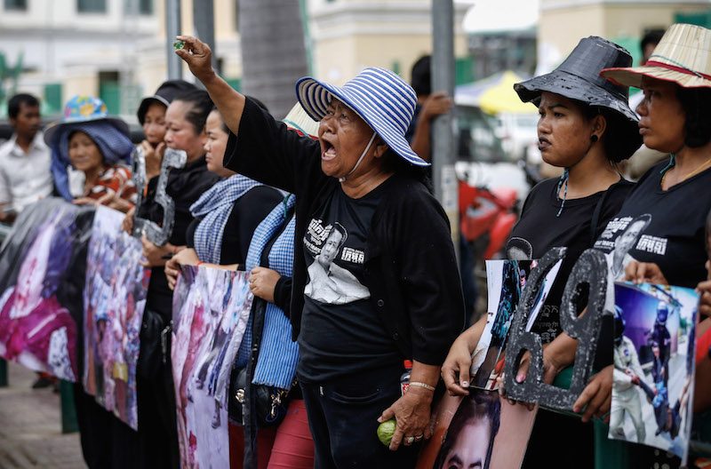 Human rights activists protest on Monday in front of the Phnom Penh Municipal Court, which heard from plaintiffs suing officials over a 2013 attack on a peaceful vigil at Wat Phnom. (Siv Channa/The Cambodia Daily)