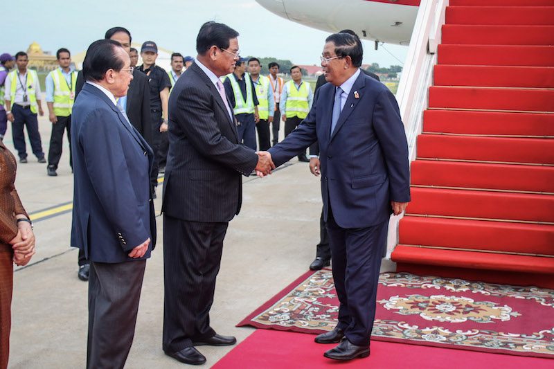 Prime Minister Hun Sen, right, shakes hands with Interior Minister Sar Kheng at Phnom Penh International Airport on Monday upon returning from the 2nd Asia Cooperation Dialogue summit in Bangkok. (Khem Sovannara)
