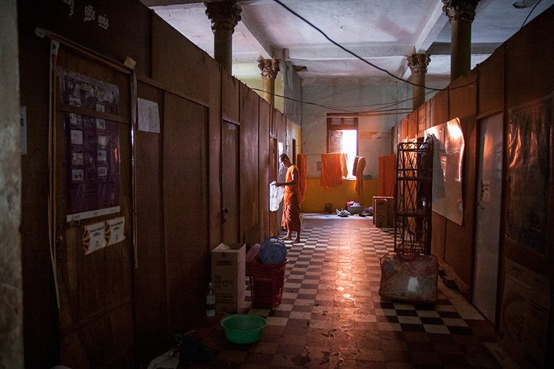 A monk stands in a hallway on Thursday as he prepares to move out of one of five residences to be demolished to make way for a new dining hall at Wat Ounalom in Phnom Penh. (Brian Leli/The Cambodia Daily)