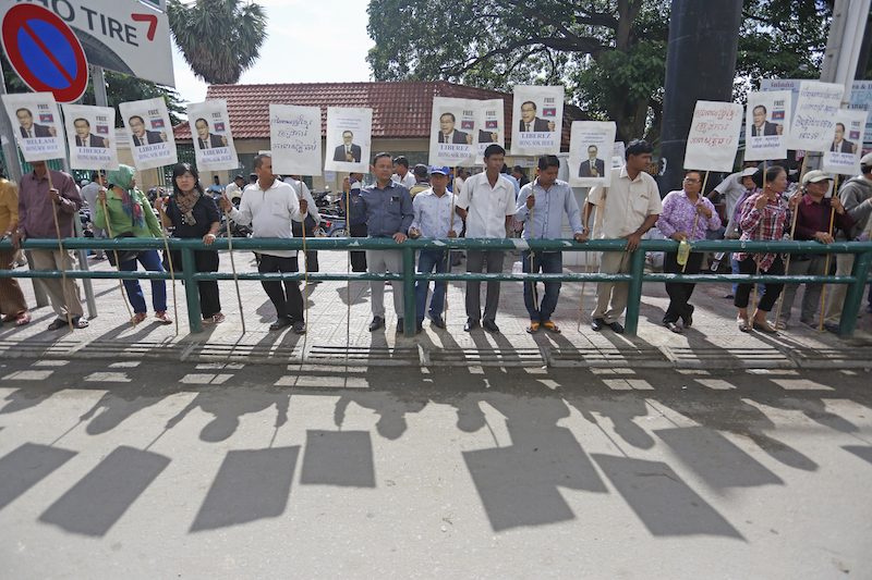 Protesters hold signs calling for the release of opposition Senator Hong Sok Hour outside the Phnom Penh Municipal Court during his trial on Wednesday. (Siv Channa/The Cambodia Daily)