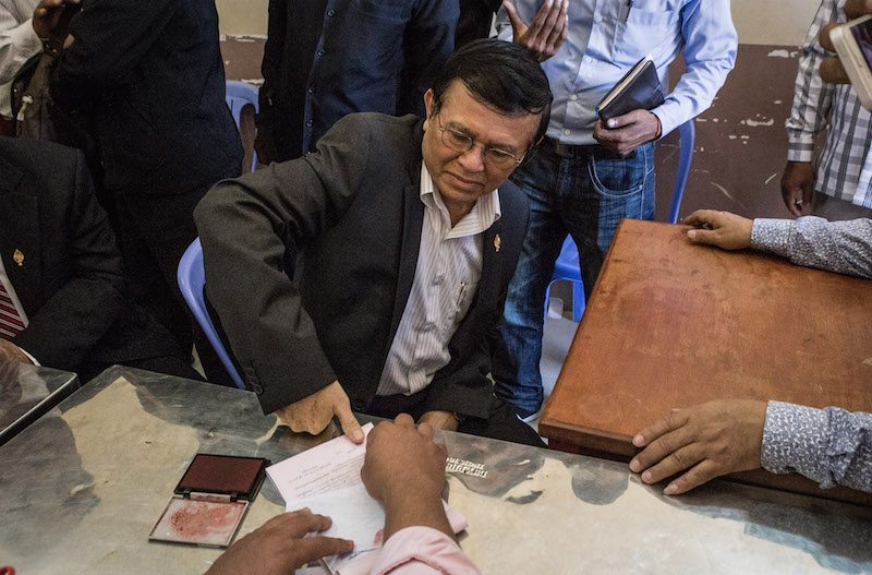 Kem Sokha thumbprints a form at a voter registration office in Phnom Penh’s Meanchey district on Wednesday. (Hannah Hawkins/The Cambodia Daily)