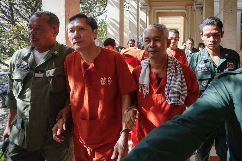 Senior Adhoc officers Ny Sokha, left, and Yi Soksan are escorted into the Court of Appeal for a hearing last month in Phnom Penh. (Siv Channa/The Cambodia Daily)