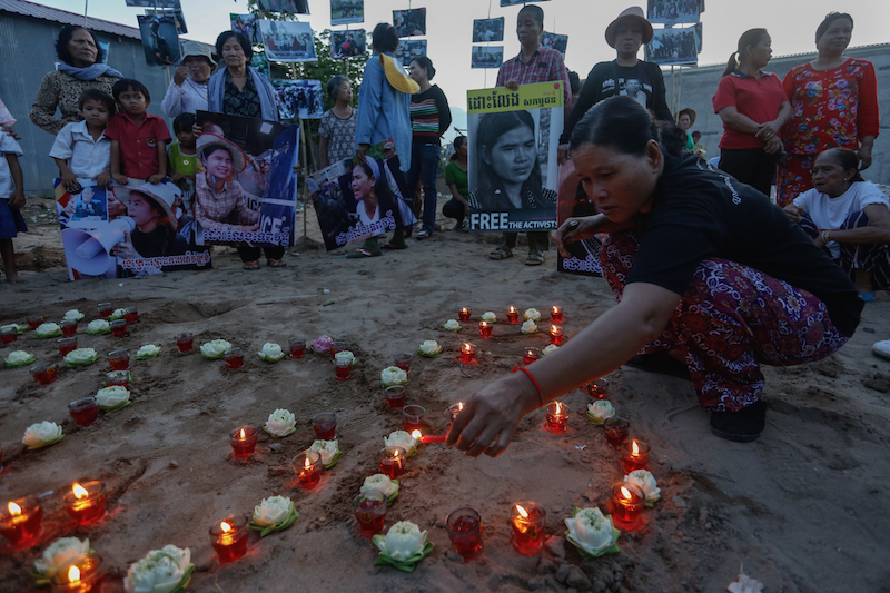 A woman lights candles during a vigil to mark “Black Monday” on Monday in Phnom Penh's Boeng Kak neighborhood. (Siv Channa/The Cambodia Daily)
