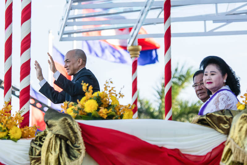 King Norodom Sihamoni waves at the Water Festival crowd on Tuesday evening with Prime Minister Hun Sen and first lady Bun Rany seated behind him. (Alex Consiglio)