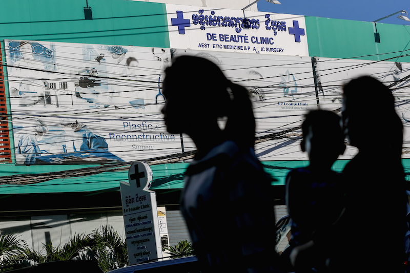 A woman walks past De Beaute Clinic in Phnom Penh’s Russei Keo district last month. (Siv Channa/The Cambodia Daily)