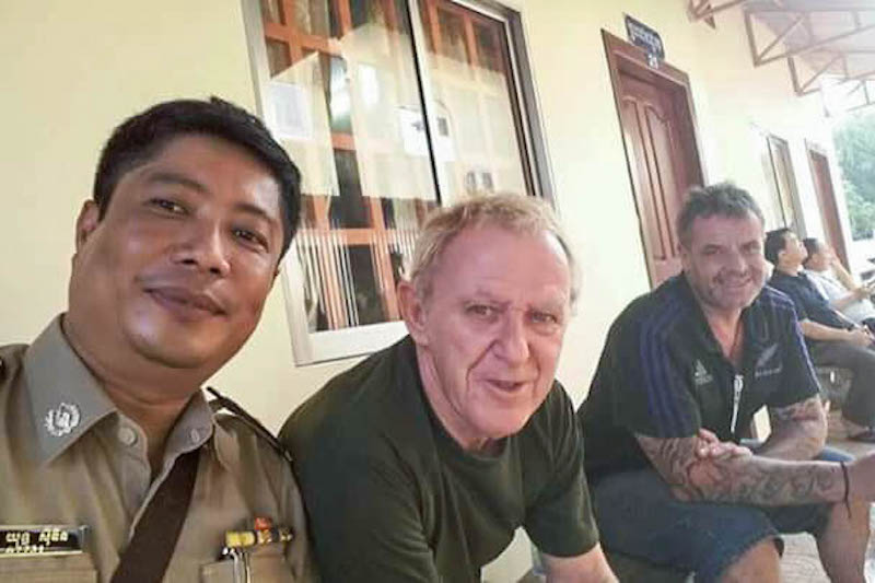 A Cambodian police officer takes a selfie, later released online, with Guido Eglitis, center, after he was arrested in Siem Reap province on October 24, 2015. 