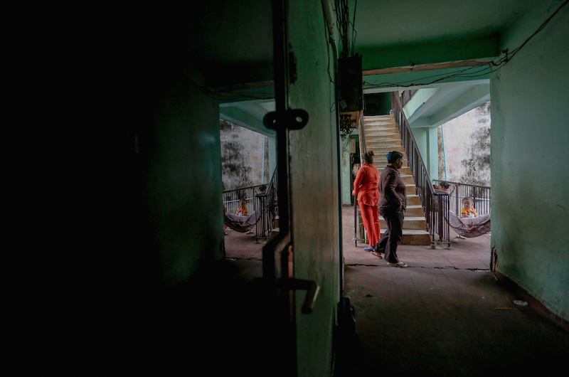 Residents walk through the halls of the White Building in Phnom Penh on Tuesday. (Siv Channa/The Cambodia Daily)