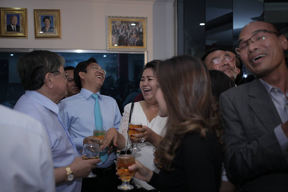 Information Minister Khieu Kanharith, far left, and Huy Vannak, second from left, laugh during a party at the UJFC’s office last month. (Photograph posted to Huy Vannak’s Facebook page)