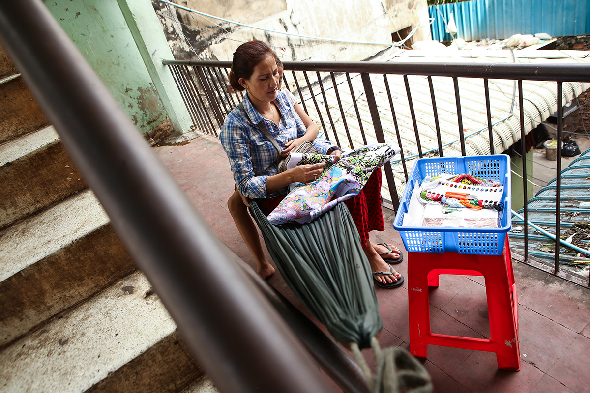 Chhit Savoeun takes a break from selling snacks outside her apartment to sit in a hammock. (Hannah Hawkins/The Cambodia Daily)