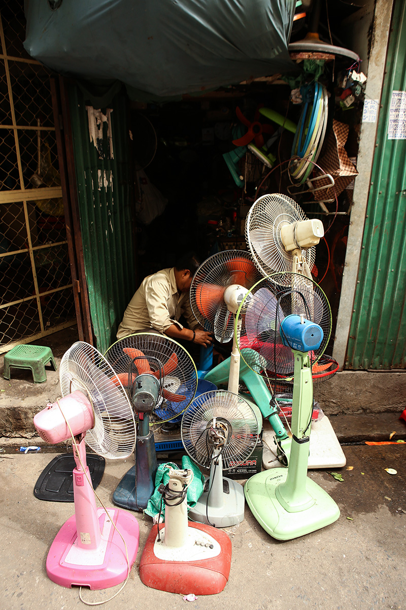 A man fixes fans at his repair shop on the ground floor of the White Building. (Hannah Hawkins/The Cambodia Daily)