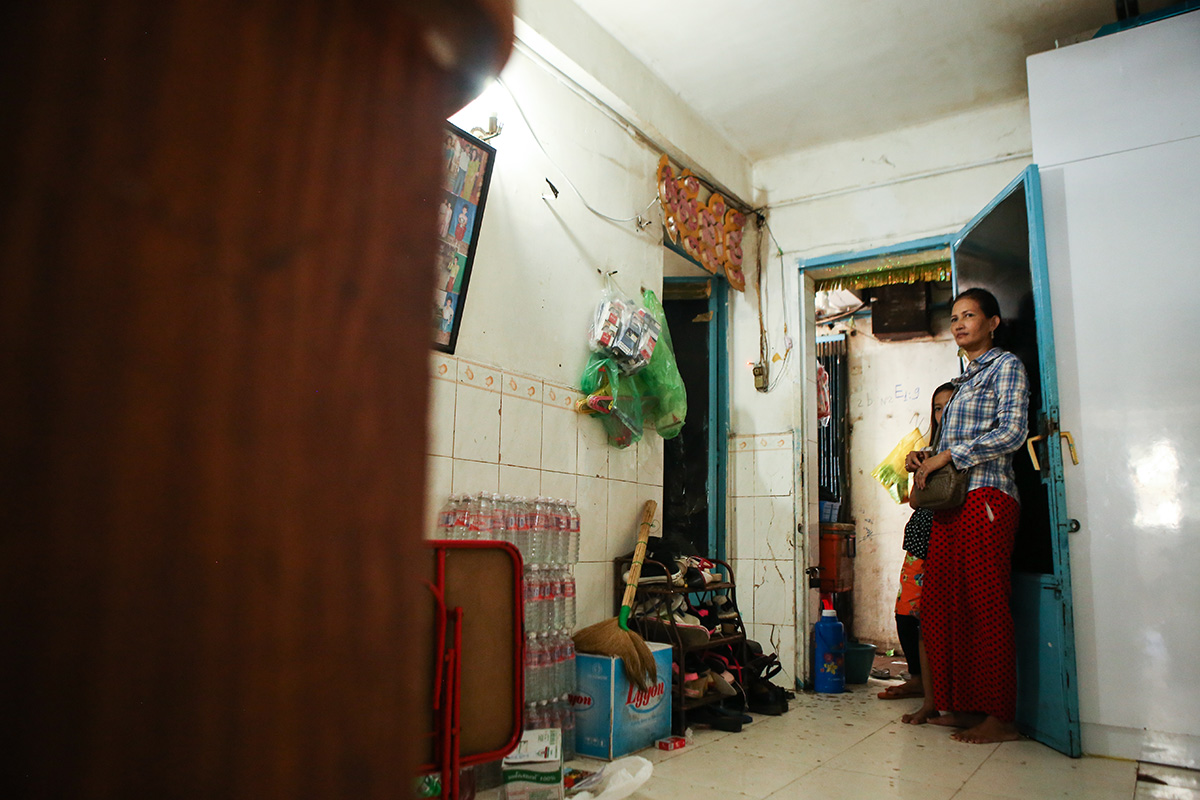 White Building resident and shop owner Chhit Savoeun watches television from her front door last week. (Hannah Hawkins/The Cambodia Daily)